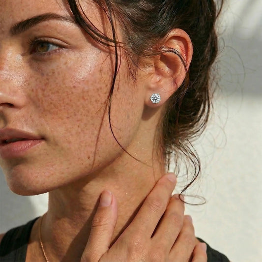 Close-up of a woman wearing a diamond earring with a blurred background.