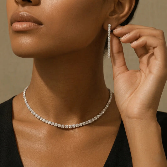 Woman wearing a zirconia necklace and matching drop earrings against a neutral background.