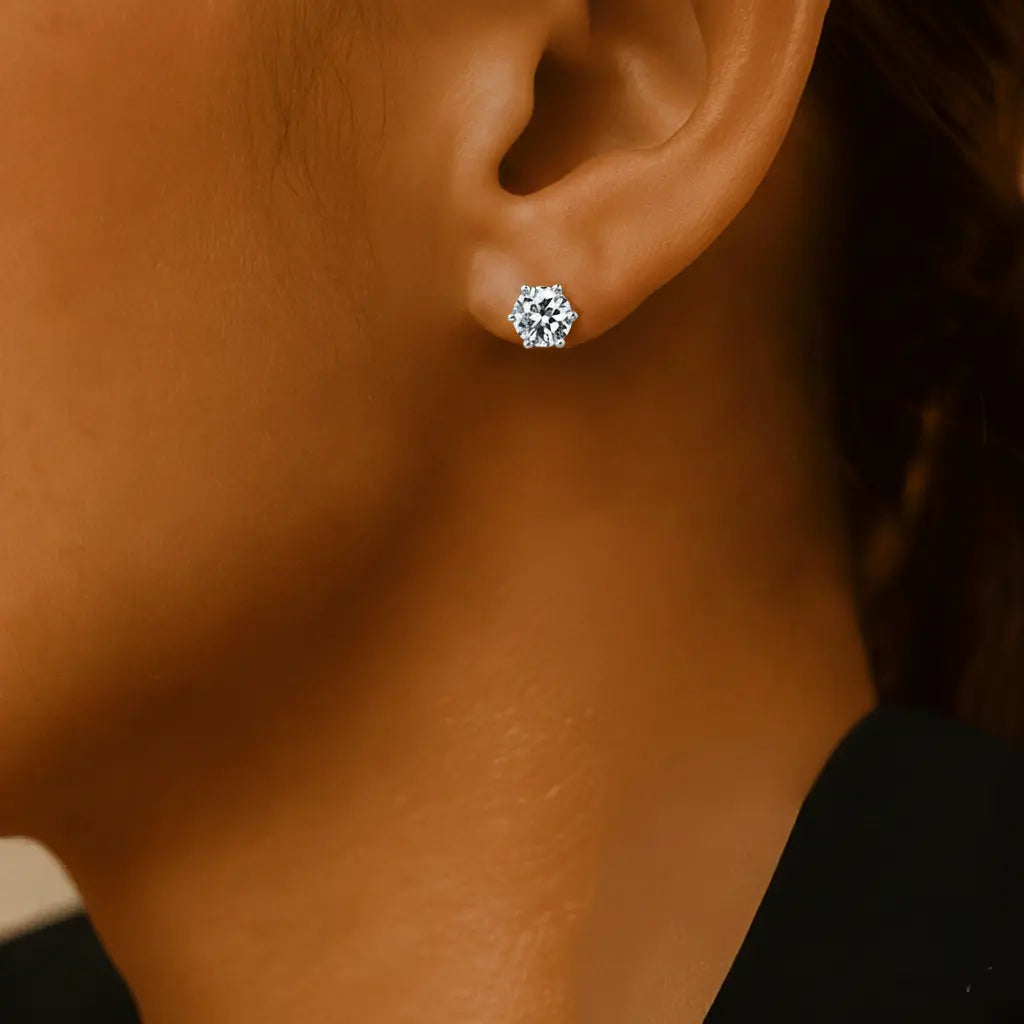 Close-up of an ear wearing a silver zirconia stud earring.