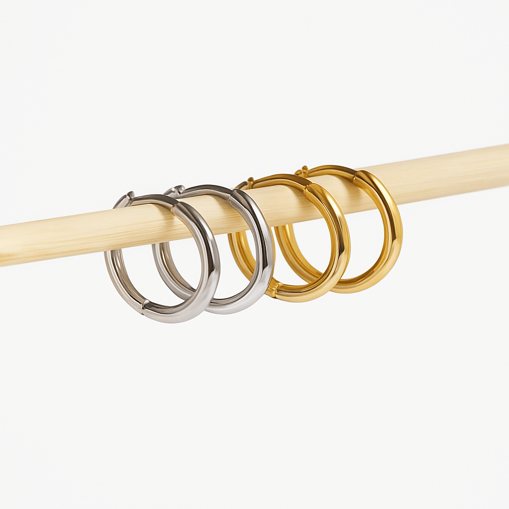 Two pairs of hoop earrings, silver and gold on a white background