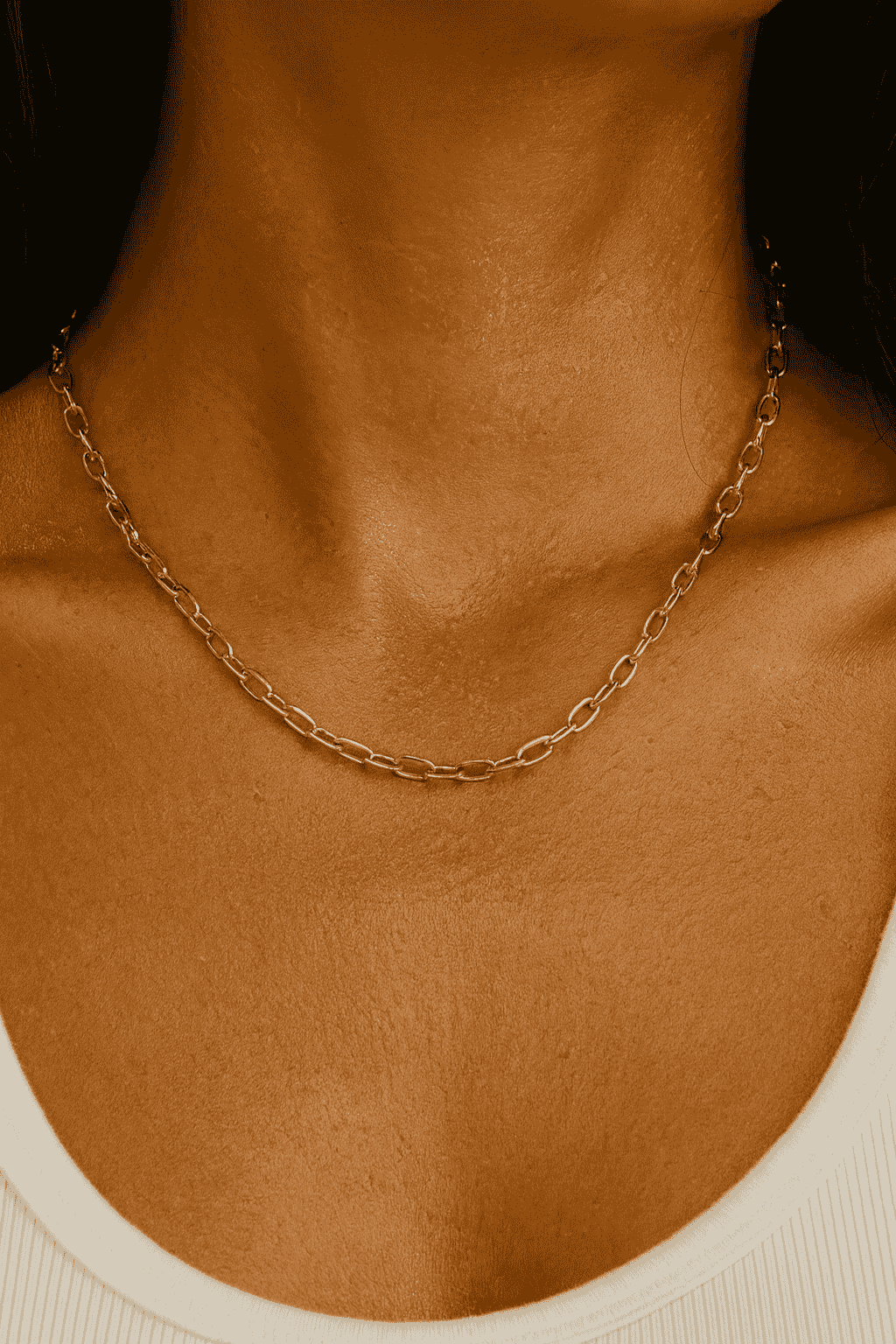 Close-up of a woman wearing a gold-plated chain necklace 