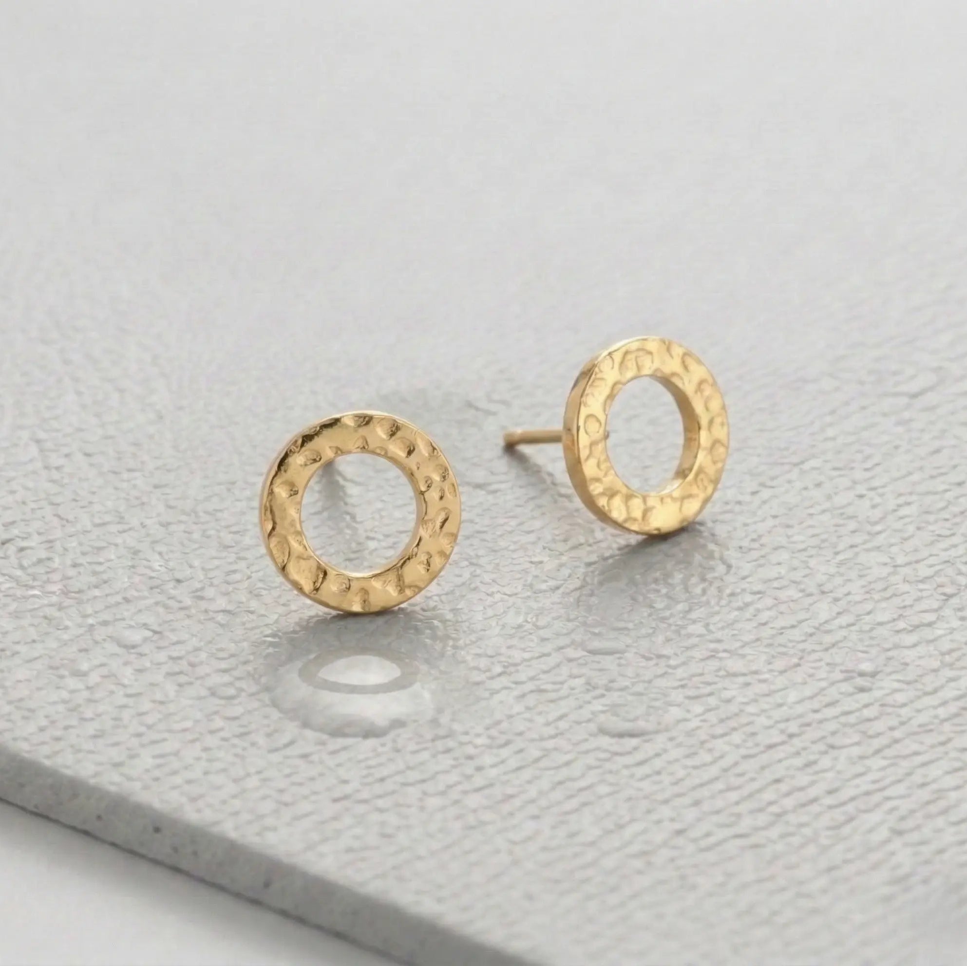 Waterproof gold circle earrings on a light gray fitness mat.