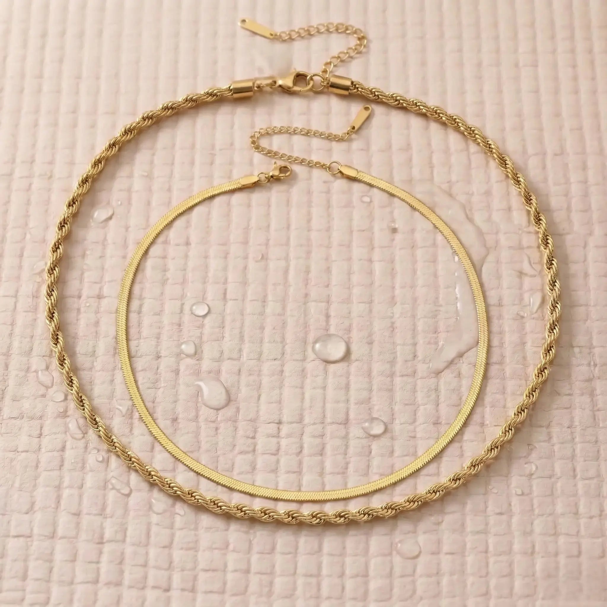 Waterproof gold double chain necklace on a pink fitness mat.