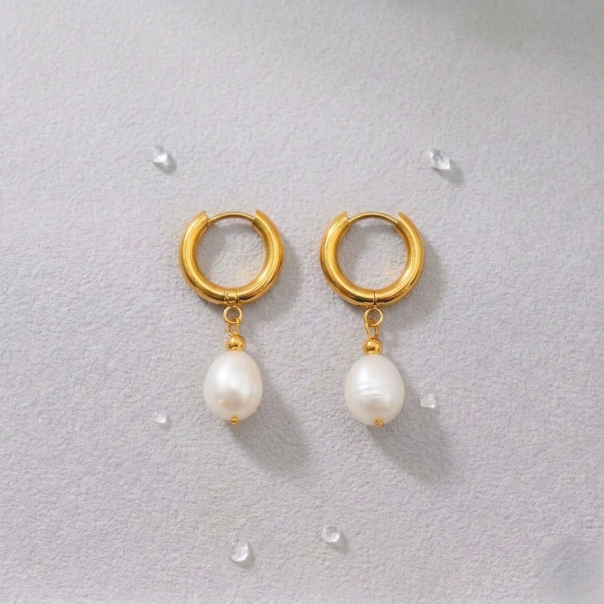 Gold-plated waterproof hoop earrings with pearl drops on a light gray background.