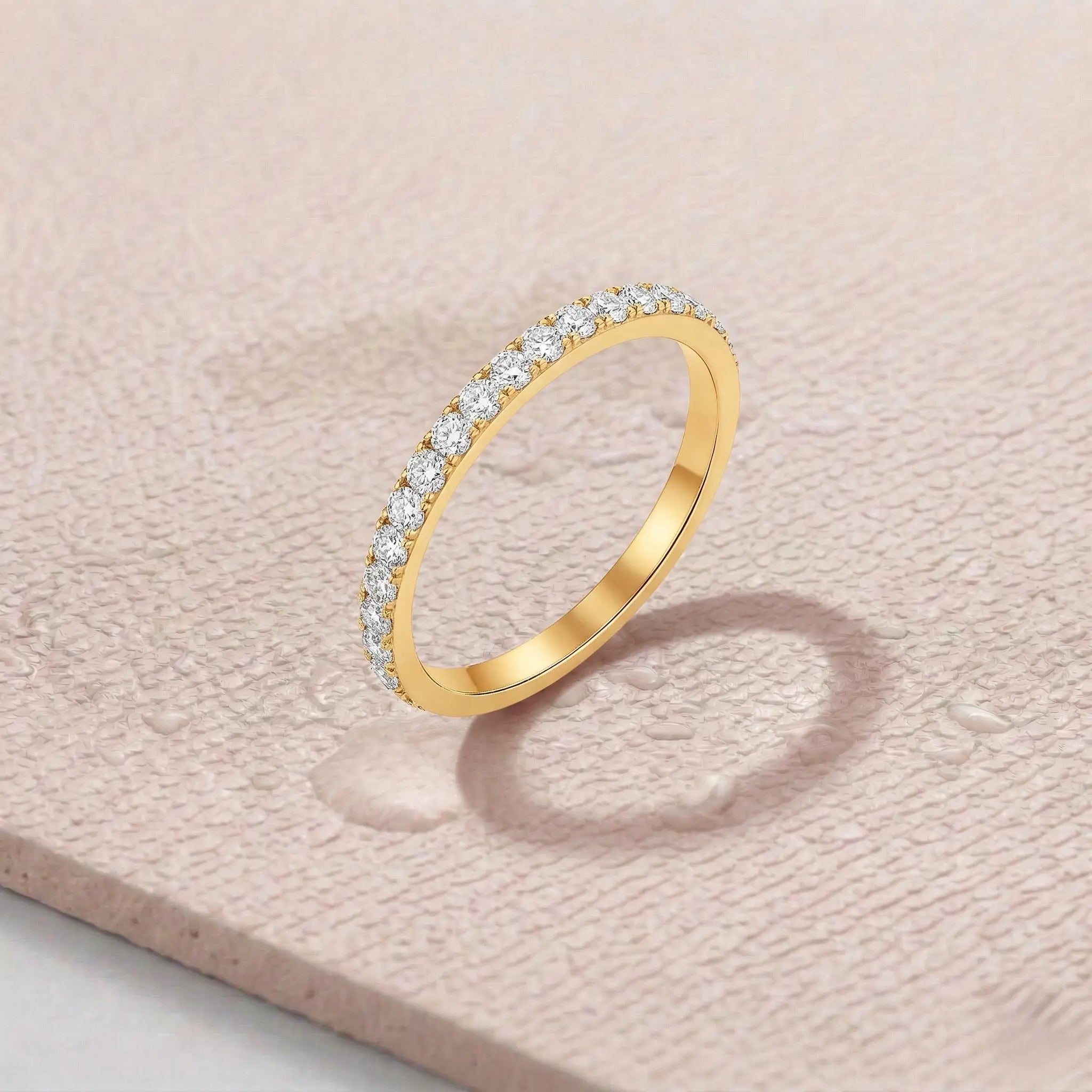 Gold ring with diamonds on a light pink fitness mat.