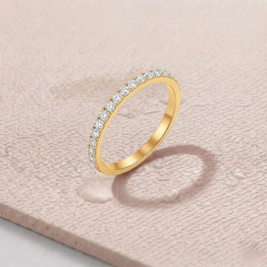 Gold ring with diamonds on a light pink fitness mat.