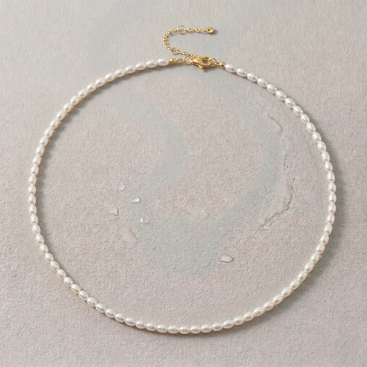 Gold waterproof pearl choker necklace on a light gray background.