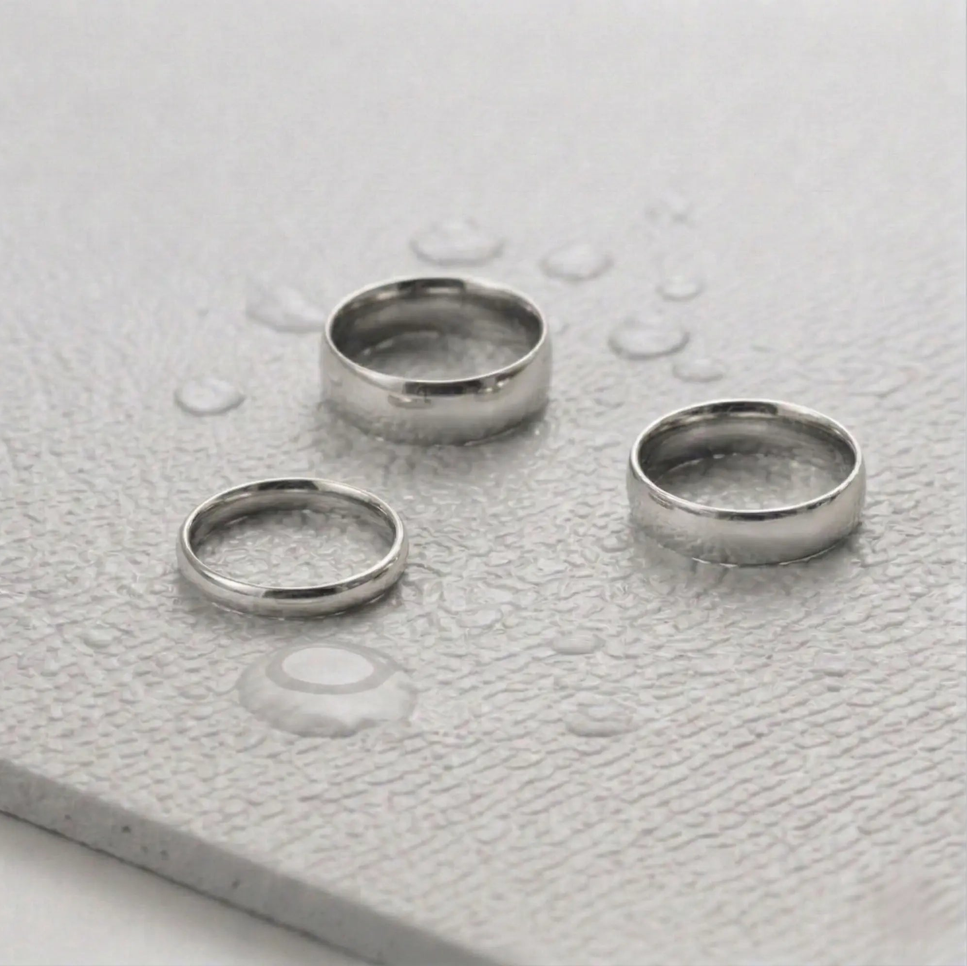 Three silver rings on a light gray fitness mat.