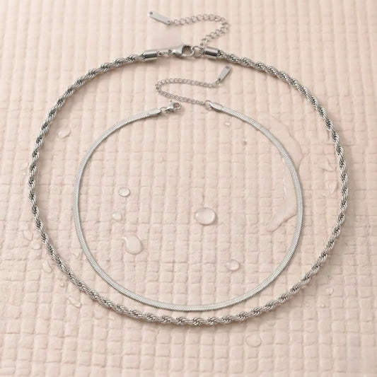 Silver-plated double chain necklace on a pink fitness mat.