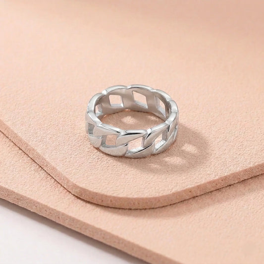 Silver stainless steel ring with a braided design on a light pink fitness mat.
