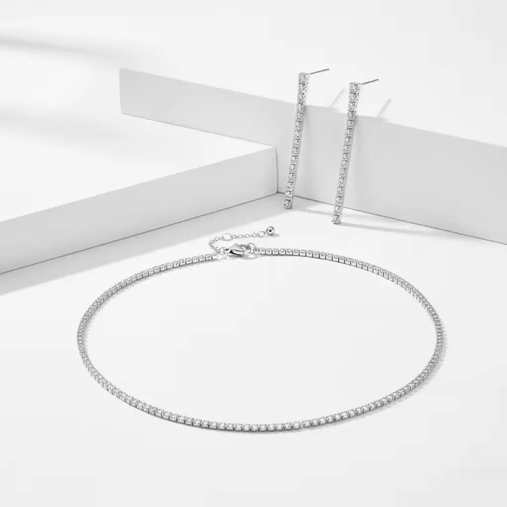 Silver zirconia necklace and matching drop earrings on a white background.