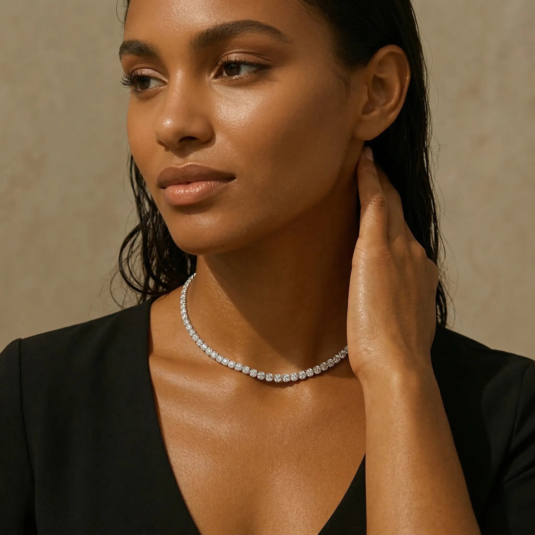 Woman wearing a silver diamond waterproof necklace against a beige background.