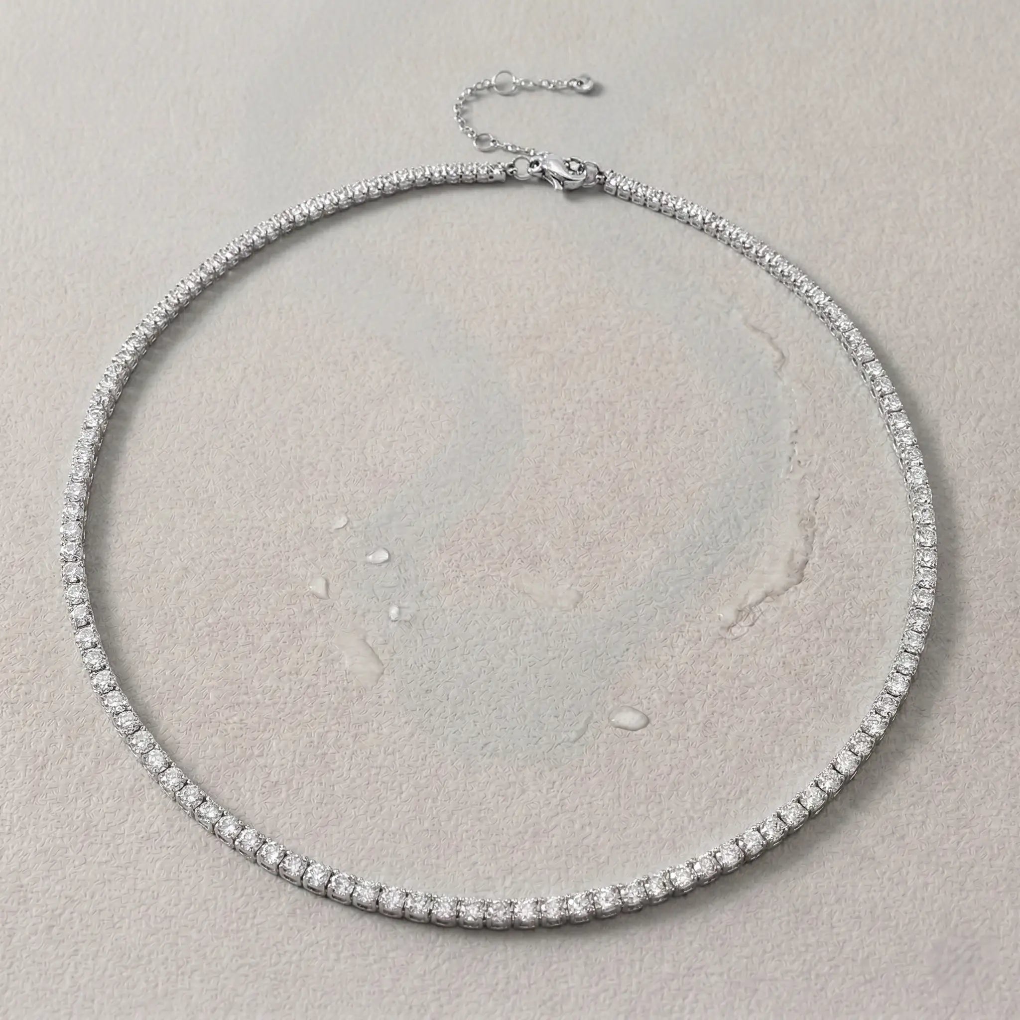 Silver sweat-resistant necklace with diamonds on a light gray background.