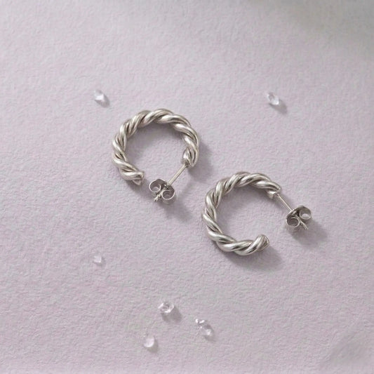 Pair of waterproof silver hoop earrings on a light gray background.