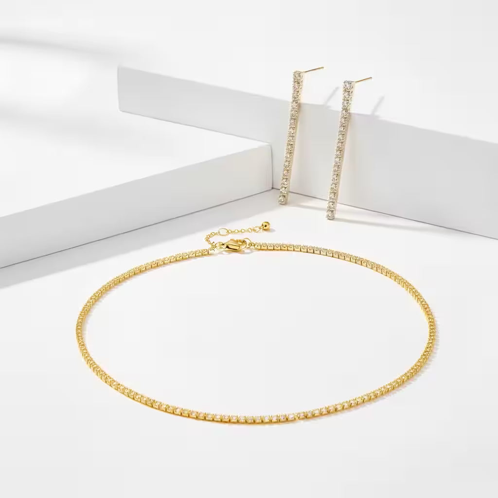 Gold zirconia necklace and matching drop earrings on a white background