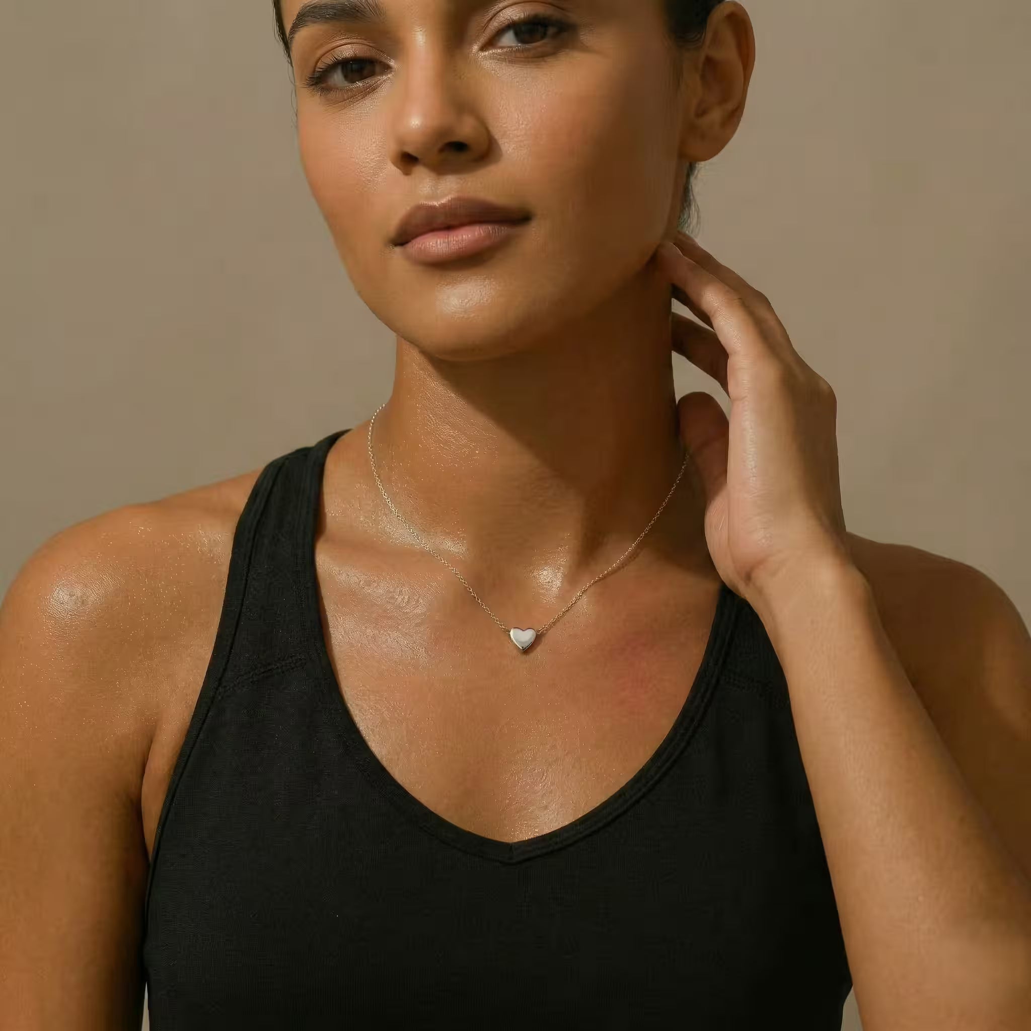 Woman wearing a black top with a silver necklace with a heart pendant