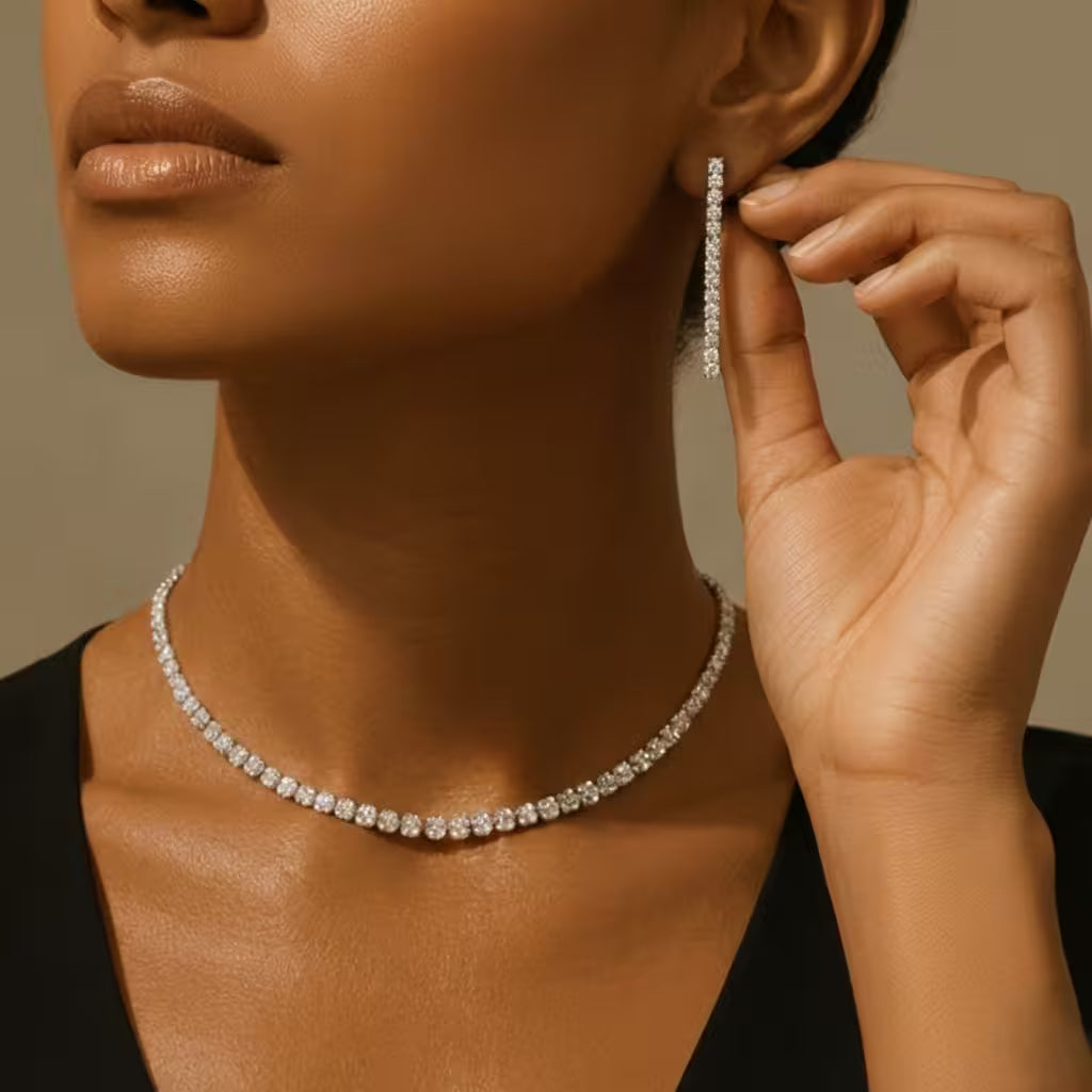 Woman wearing a zirconia necklace and matching drop earrings against a neutral background