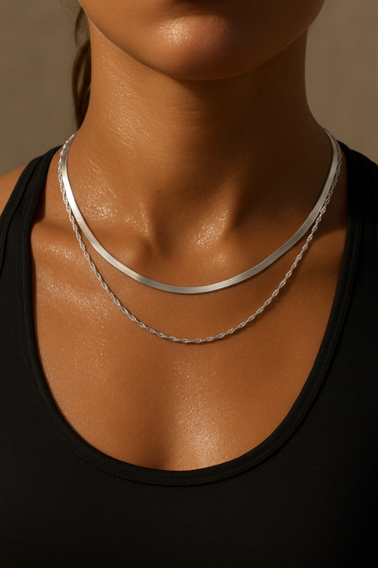 Close-up of a woman wearing two waterproof silver necklaces