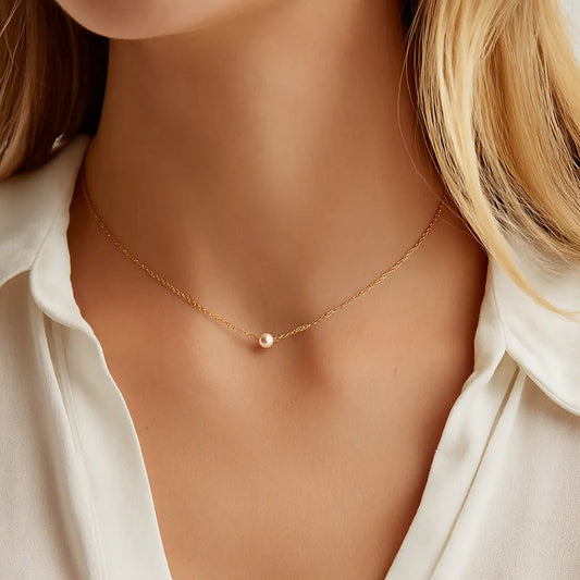 Gold waterproof necklace with a single pearl pendant on a woman.