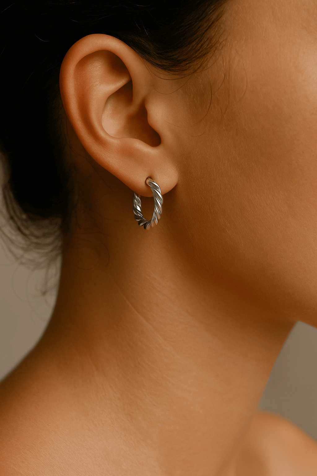 Close-up of an ear wearing a silver plated hoop earring 